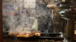 Yakitori saat dibakar di sebuah bar di area jalan malam belakang pusat kota Tokyo (4/10/2019). Yakitori merupakan sate khas dari Jepang yang umumnya menggunakan daging ayam.  (AP Photo/Mark Baker)