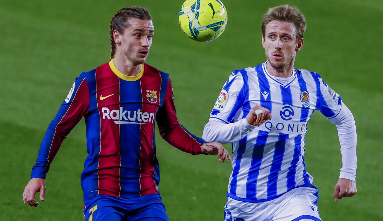 Penyerang Barcelona, Antoine Griezmann berebut bola dengan pemain Real Sociedad, Nacho Monreal pada pertandingan lanjutan La Liga Spanyol di stadion Camp Nou di Barcelona, Spanyol, Kamis (17/12/2020). Rambut kepang dua Griezmann juga dipamerkan dalam akun Instagram klub. (AP Photo/Joan Monfort)
