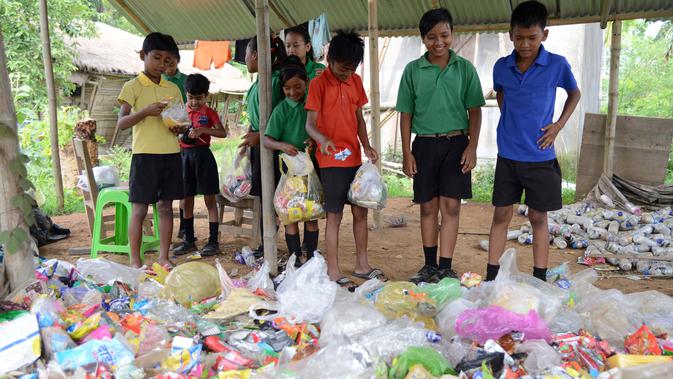 Gambar pada 20 Mei 2019, siswa India mengumpulkan sampah plastik sebagai pengganti biaya sekolah di sekolah Forum Akshar di desa Pamohi, Guwahati. Sebanyak 110 murid sekolah ini harus membawa 20 item sampah plastik per minggu yang dikumpulkan dari rumah atau area sekitar mereka. (Biju BORO/AFP)