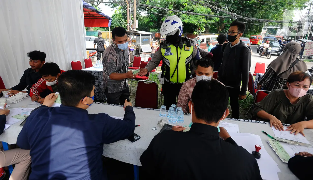 Polantas Polres Depok memeriksa surat tanda nomor kendaraan (STNK) saat Operasi Gabungan Tertib Administrasi Kendaraan Bermotor (KBM) Kendaraan Tidak Mendaftar Ulang (KTMDU) 2022 di Jembatan Panus, Depok, Kamis (9/6/2022). Ratusan kendaraan bermotor yang belum membayar pajak atau kendaraan tidak melakukan daftar ulang (KTMDU) terjaring dalam razia yang dilakukan Sistem Administrasi Manunggal Satu Atap (Samsat) Depok ini. (merdeka.com/Arie Basuki)