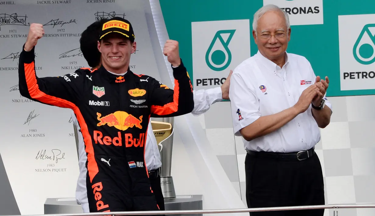 Pembalap Red Bull asal Belanda, Max Verstappen (kiri) merayakan kemenangan samping Perdana Menteri Malaysia, Najib Razak setelah menjuarai Formula 1 Grand Prix Malaysia di Sepang, Minggu (01/10) (AFP PHOTO / ROSLAN RAHMAN)