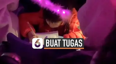 Pemandangan tak biasa terekam kamera salah satu penonton saat menikmati konser musisi Taiwan, Jay Chou. Ada seorang gadis kecil yang mengerjakan tugas ekolah di kursi penonton.