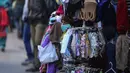 Seorang anak pedagang yang mengenakan masker menunggu pelanggan di sebuah pasar di Jammu, Rabu (29/12/2021). Di India, yang telah kembali normal setelah dihantam tsunami COVID-19 tahun ini, omicron sekali lagi menimbulkan ketakutan, dengan lebih dari 700 kasus dilaporkan. (AP Photo/Channi Anand)