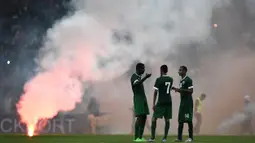 Para pemain Arab Saudi menunggu petugas mematikan suar saat berlaga melawan Malaysia pada Pra Piala Dunia 2018 di Malaysia, Selasa (8/9/2015). Suar dinyalakan pendukung Malaysia yang kecewa. (AFP Photo/Manan Vatsyayana)