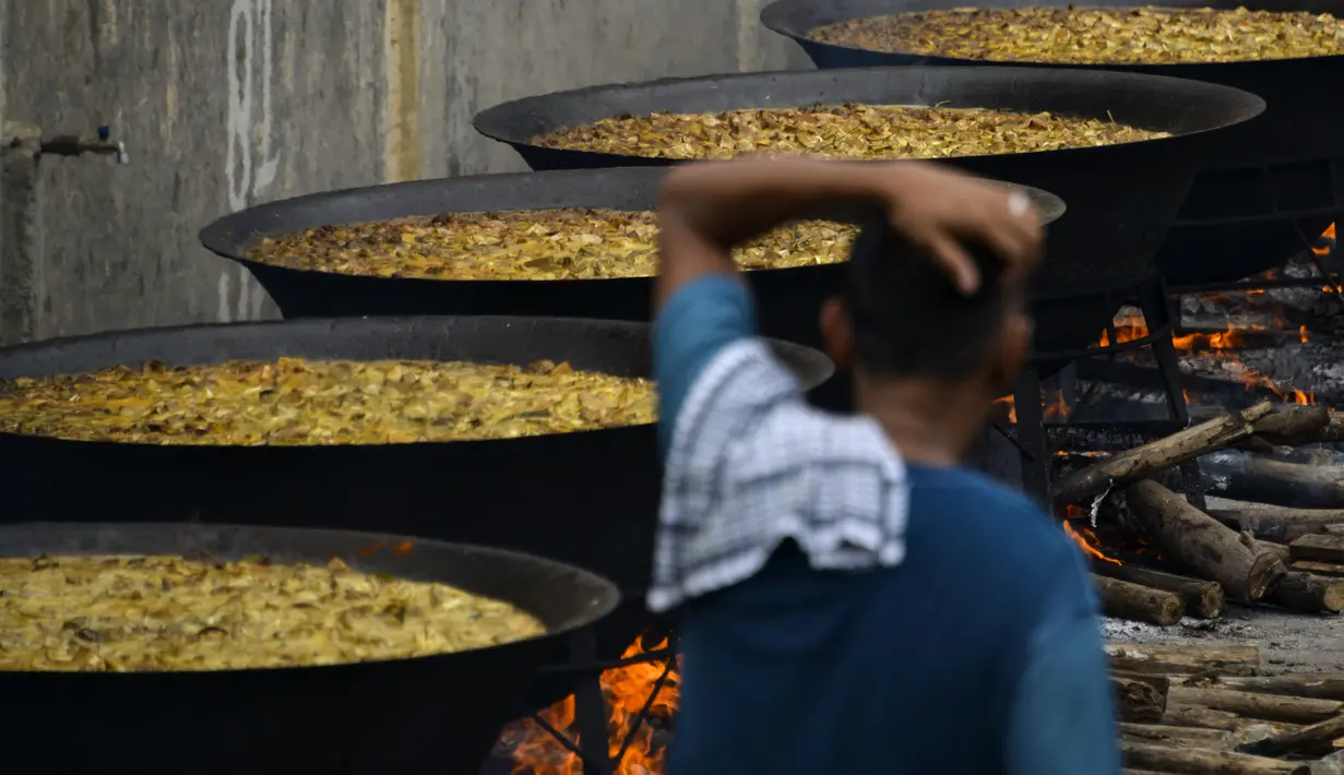 Seorang pria memasak kari tradisional untuk disajikan dalam makanan komunal selama bulan suci Ramadhan di Banda Aceh (25/4/2021). Menu ini sering dimasak setiap memperingati kenduri Nuzul Quran pada setiap pertengahan bulan suci Ramadhan. (AFP/Chaideer Mahyuddin)