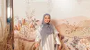 Sheza Idris tampil cantik dalam balutan abaya lebar berwarna putih yang semarak. Abaya ini memiliki motif floral yang super cantik dengan detail ruffles di bagian lengan. Ia padukan penampilannya dengan hijab abu-abu yang menutupi area dada. Foto: Instagram.