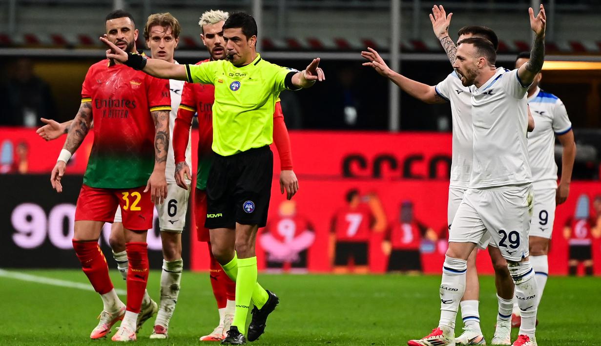 Wasit Gianluca Manganiello (tengah) memberi isyarat di samping bek AC Milan Kyle Walker (kiri) dan gelandang Lazio Manuel Lazzari saat pertandingan ke- 27 Serie A Italia 2024/2025 di stadion San Siro, Milan, pada Minggu 2 Maret 2025 waktu setempat atau Senin (3/3/2025) dini hari WIB. (Piero CRUCIATTI/AFP)