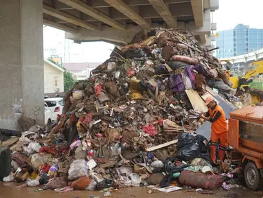 Petugas mengangkut sampah sisa banjir yang menumpuk di kawasan Cipinang Melayu, Jakarta, Senin (6/1/2020). Banjir yang menggenangi Jakarta dan sekitarnya sejak 1 Januari 2020 lalu menyisakan tumpukan sampah di sejumlah titik. (Liputan6.com/Immanuel Antonius)