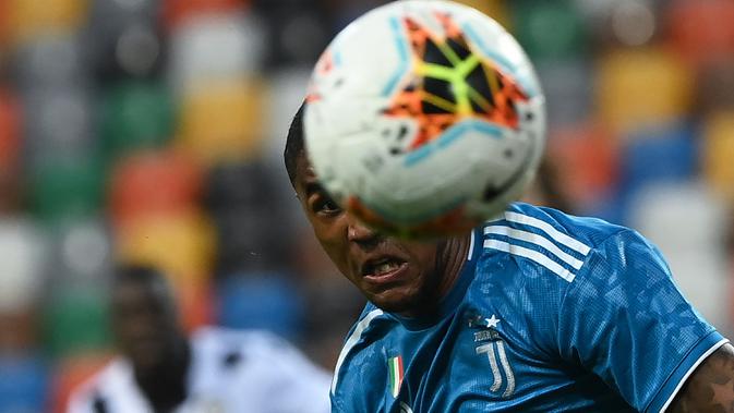 Gelandang Juventus, Douglas Costa menyundul bola saat bertanding melawan Udinese pada pertandingan lanjutan Liga Serie A Italia di Stadion Dacia Arena di Udine (23/7/2020). Udinese menang 2-1 atas Juventus. (AFP Photo/Marco Bertorello)