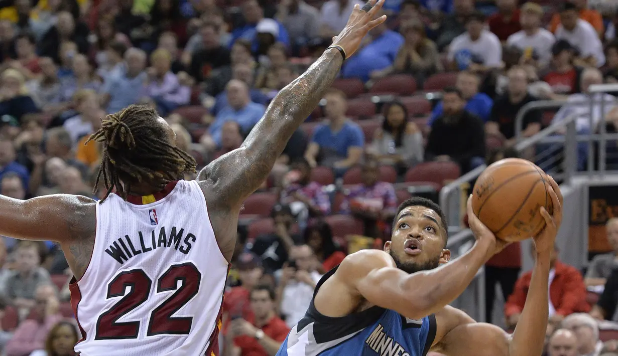 Pemain Minnesota Timberwolves Karl-Anthony Towns #32 berusaha melakukan tembakan saat dihadang pemain Miami Heat, Derrick Williams #22 pada laga NBA preseason basketball game di Louisville, (15/10/2016). (AP/Timothy D. Easley)