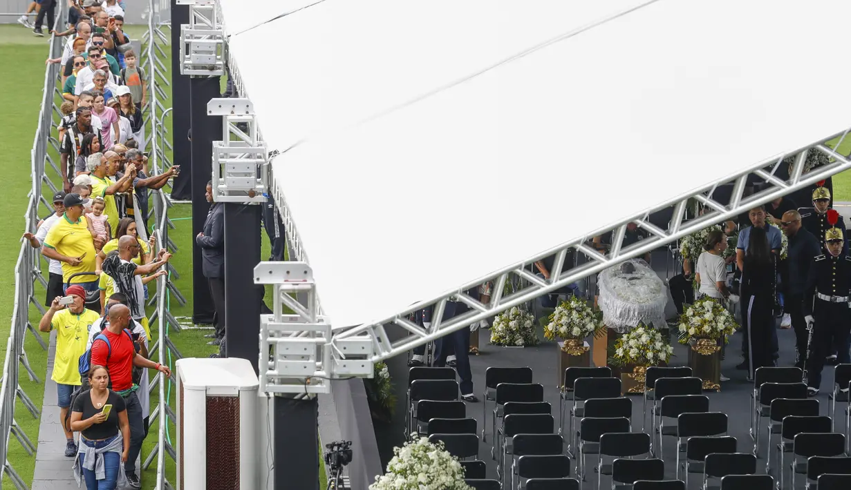 Warga Brasil mengantre untuk memberikan penghormatan terakhir kepada legenda sepak bola Brasil Pele di stadion Vila Belmiro di Santos, Brasil, Senin, 2 Januari 2023. Pintu stadion dibuka pukul 10.00 pagi waktu setempat, atau 20.00 WIB. Masyarakat memiliki kesempatan untuk datang hingga Selasa (3/1/2023) pukul 10.00. (AP Photo/Marcelo Chello)