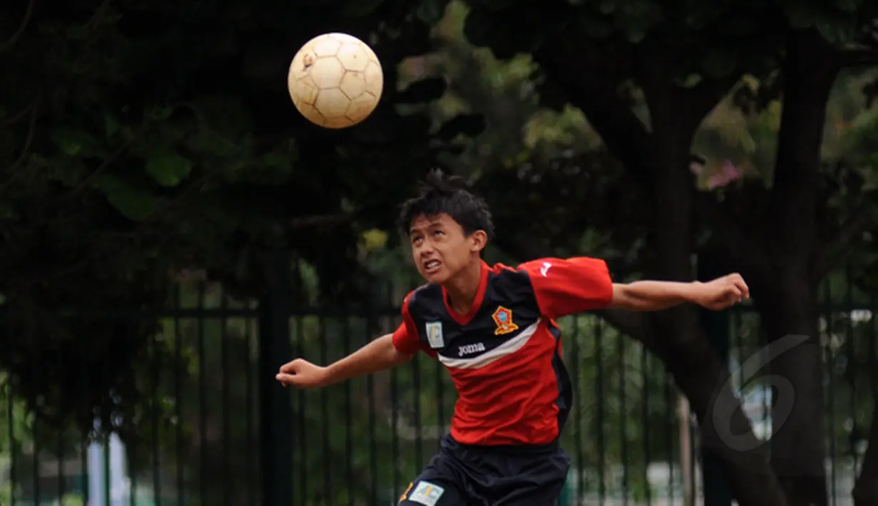 Salah satu anak berlatih menyundul bola di Sekolah Sepak Bola (SSB) ASIOP Apacinti di Lapangan A Senayan, Jakarta, Jumat (20/2/2015). (Liputan6.com/Helmi Fithriansyah)