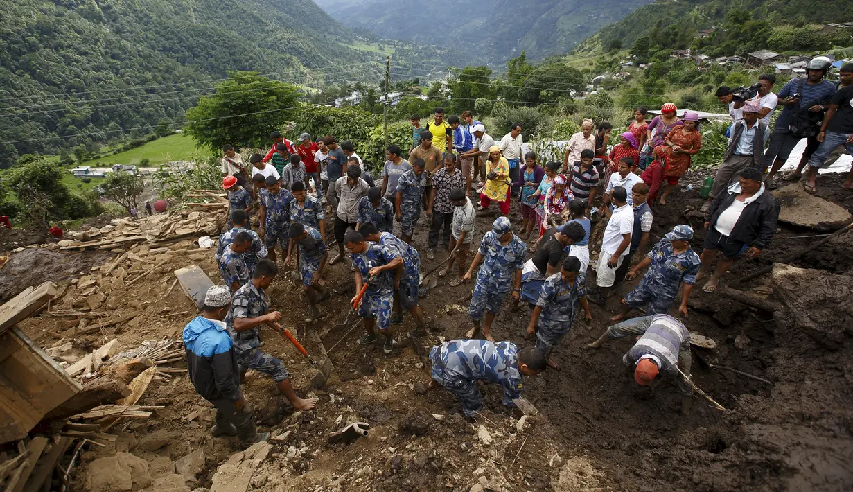 Tim SAR dibantu warga mencari korban selamat yang tertimbun bangunan pasca longsor di Desa Lumle, Nepal (30/7/2015). Tanah longsor yang dipicu hujan deras tersebut menewaskan sedikitnya 30 orang dan menghacurkan puluhan rumah. (REUTERS/Navesh Chitrakar)