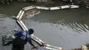 Hal ini dilakukan melalui pemasangan jaring, penghalang sampah, pengangkutan, hingga pengolahan sampah. (David GANNON/AFP)