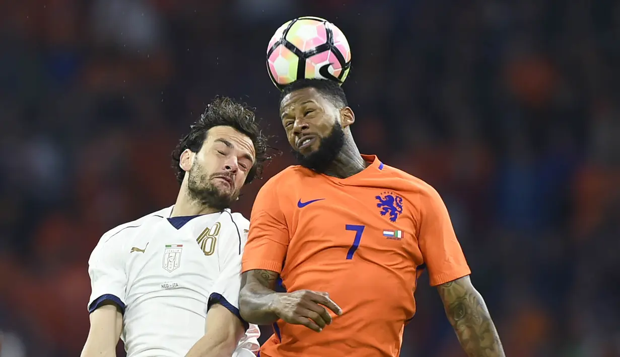 Gelandang Italia, Marco Parolo, duel udara dengan striker Belanda, Jeremain Lens. Belanda sebenarnya tampil lebih mendominasi dengan penguasaan bola hingga 56 persen sedangkan Italia hanya 44 persen. (AFP/John Thys)