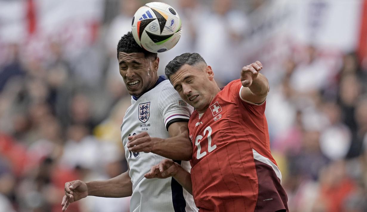 <p>Pemain Inggris, Jude Bellingham berduel udara dengan pemain Swiss, Fabian Schaer saat laga perempat final Euro 2024 di Duesseldorf Arena, Duesseldorf, Jerman, Sabtu (06/07/2024). (AP Photo/Thanassis Stavrakis)</p>