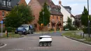 Robot otonom bernama Starship melakukan perjalanan untuk mengantarkan bahan makanan dari supermarket Co-op di Milton Keynes, Inggris, 20 September 2021. Robot Starship bertugas mengantarkan belanja dan makanan. (DANIEL LEAL-OLIVAS/AFP)