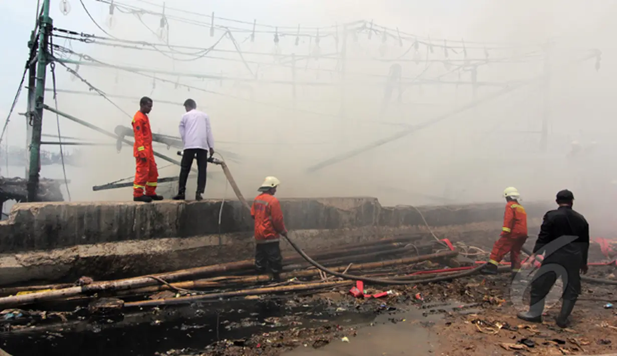 Sejumlah petugas pemadam kebakaran tampak berada di lokasi tempat kapal terbakar di Pelabuhan Muara Angke, Jakarta, Jumat (27/2/2015). Diduga kebakaran disebabkan korsleting listrik. Kerugian ditaksir mencapai ratusan juta. (Liputan6.com/Johan Tallo)
