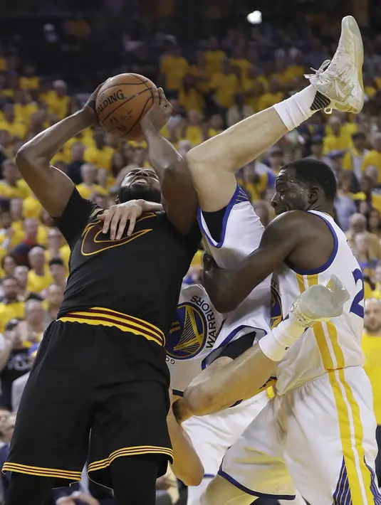 Pemain Cleveland, Tristan Thompson (kiri) berjibaku dengan pemain Warriors, Klay Thompson (tengah) dan Draymond Green pada final NBA di Oracle Arena, Oakland, (12/6/2017). Warriors menang 129-120. (AP/Marcio Jose Sanchez)