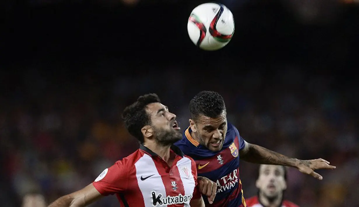 Bek Athletic Bilbao, Mikel Balenziaga (kiri) berebut bola udara dengan Bek Barcelona, Daniel Alves di leg kedua Piala Super Spanyol di stadion Camp Nou, Barcelona, Spanyol, (18/8/2015).  Athletic Bilbao menang dengan agregat akhir 1-5. (AFP/JOSEP LAGO)