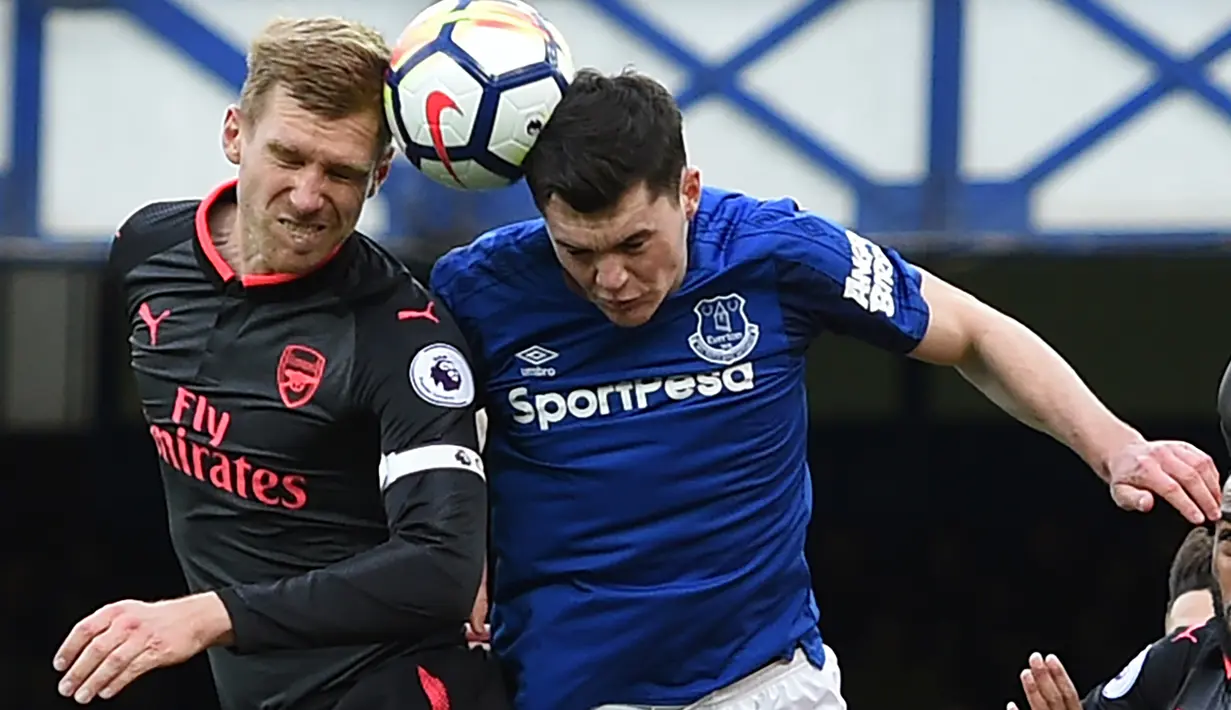 Bek Arsenal, Per Mertesacker (kiri) dan bek Everton, Michael Keane berebut bola pada matchday kesembilan Liga Primer Inggris di Goodison Park, Minggu (22/10). Bertandang ke markas Everton, Arsenal berhasil mengukir kemenangan telak 5-2. (Oli SCARFF / AFP)