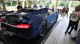 Pengunjung mengamati replika mobil Bugatti Chiron dari jutaan balok Lego Technic pada sebuah pameran di Taman Gorky Moskow, Selasa (23/7/2019). Mobil replika ini bisa dikendarai oleh dua orang dan mampu berakselerasi hingga kecepatan 20 km/jam. (Alexander NEMENOV/AFP)