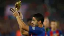 Striker Barcelona, Luis Suarez, menunjukan Sepatu Emas jelang laga La Liga melawan Granada di Stadion Nou Camp, Spanyol, Sabtu (29/10/2016). Suarez meraih gelar ini usai mencetak 40 gol pada musim lalu. (Reuters/Albert Gea)