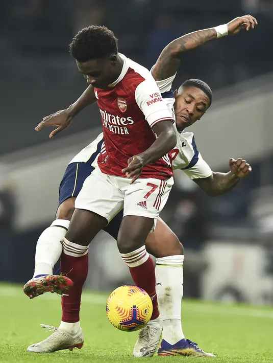 Gelandang Arsenal, Bukayo Saka berusaha mengontrol bola dari kawalan penyerang Tottenham Hotspur, Steven Bergwijn pada pertandingan lanjutan Liga Inggris di Tottenham Hotspur Stadium di London, Inggris , Minggu (7/12/2020). Tottenham menang 2-0. (Glyn Kirk/Pool via AP)
