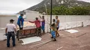 Pekerja memasang pagar untuk memblokir akses ke Pantai Shek O di Hong Kong, Kamis (17/3/2022). Pemerintah Hong Kong mengatakan akan menutup pantai umum untuk mengekang penyebaran virus corona COVID-19. (DALE DE LA REY/AFP)