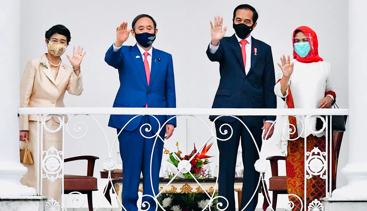 Presiden Joko Widodo (kedua kanan) didampingi Ibu Negara Iriana Joko Widodo (kanan) bersama PM Jepang Yoshihide Suga (kedua kiri) bersama Madam Suga Mariko (kiri) melambaikan tangan saat menerima kunjungan di Istana Bogor, Selasa (20/10/2020). (Laily Rachev/Indonesian Presidential Palace via AP)