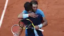 Rafael Ndal memberikan saaat memeluk Dominic Thiem usai laga final Prancis Terbuka 2018 di Roland Garros stadium, Paris, (10/6/2018). Nadal menang tiga set 6-4, 6-3, 6-2. (AP/Christophe Ena)