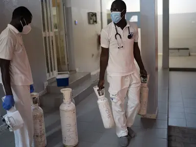 Mobile Emergency Care Service (SAMU) membawa botol oksigen ke ambulans mereka di Dakar, Senegal, pada 5 Agustus 2021. Layanan ambulans di negara Afrika Barat, Senegal, mengatakan sekitar 90 persen panggilan mereka saat ini merespons pasien COVID-19 yang kesulitan bernapas. (AP Photo/Leo Correa)