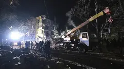 Petugas darurat membersihkan puing-puing setelah roket Rusia menghantam sebuah gedung apartemen di Kramatorsk, Ukraina, pada Kamis, 2 Februari 2023. Sedikitnya 3 orang tewas dan 21 luka-luka dalam serangan itu. (AP Photo/Yevgen Honcharenko)