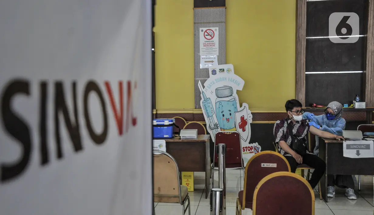 Warga menerima vaksinasi Covid-19 dosis kedua di Gelanggang Remaja Pulogadung, Rawamangun, Jakarta, Kamis (18/11/2021). Kementerian Kesehatan mencatat, capaian vaksinasi dosis kedua di Indonesia hingga Kamis (18/11) pukul 12.00 telah mencapai 86.335.923 orang. (merdeka.com/Iqbal S. Nugroho)