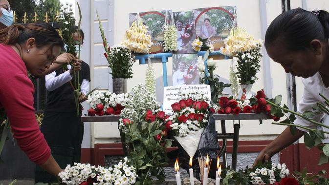 Orang-orang mempersembahkan bunga mawar sebagai penghormatan kepada seorang guru yang tewas dalam protes kudeta militer di Yangon, Myanmar, Senin (1/3/2021). Aksi demonstrasi menolak kudeta militer pada Minggu tersebut dilaporkan berubah menjadi kerusuhan. (AP Photo)