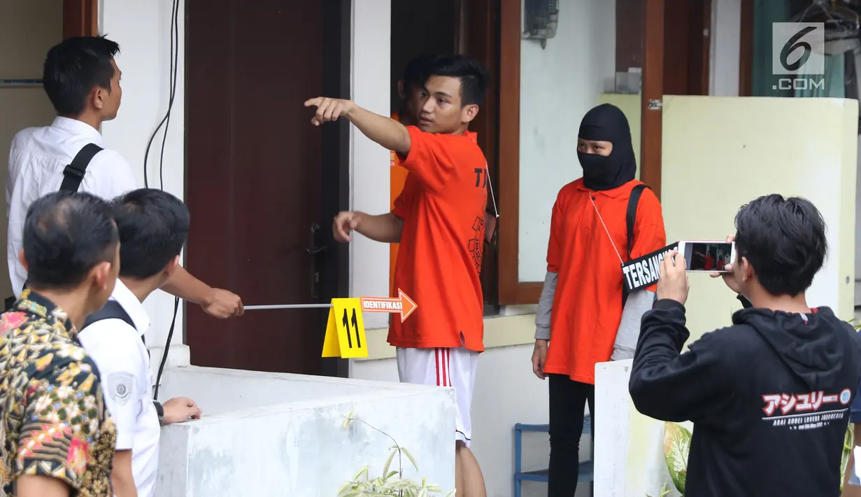 Dua tersangka pembunuhan wanita yang ditemukan tewas di dalam lemari memeragakan adegan peristiwa di Tempat Kejadian Perkara di kawasan Mampang, Jakarta, Jumat (23/11). 13 adegan dilakukan tersangka dalam rekonstruksi. (Liputan6.com/Helmi Fithriansyah)