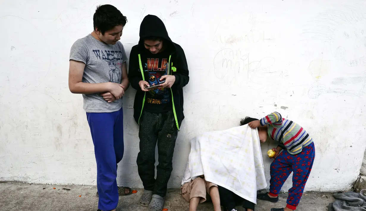 Sejumlah pengungsi saat beraktivitas di Kamp Oinofyta, Athena, Yunani (13/3). Kamp ini merupakan rumah bagi para pengungsi atau imigran, terutama dari Afghanistan. (AFP Photo / Louisa Gouliamaki)