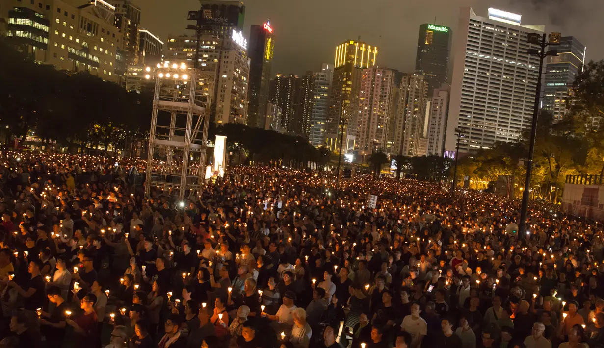 Ribuan warga  Hong Kong menyalakan lilin memperingati peristiwa Tiananmen di Hong Kong's Victoria Park, (4/6). Mereka mengenang tindakan brutal militer Tiongkok saat membubarkan demo mahasiswa di Lapangan Tiananmen. (AP Photo/Kin Cheung)