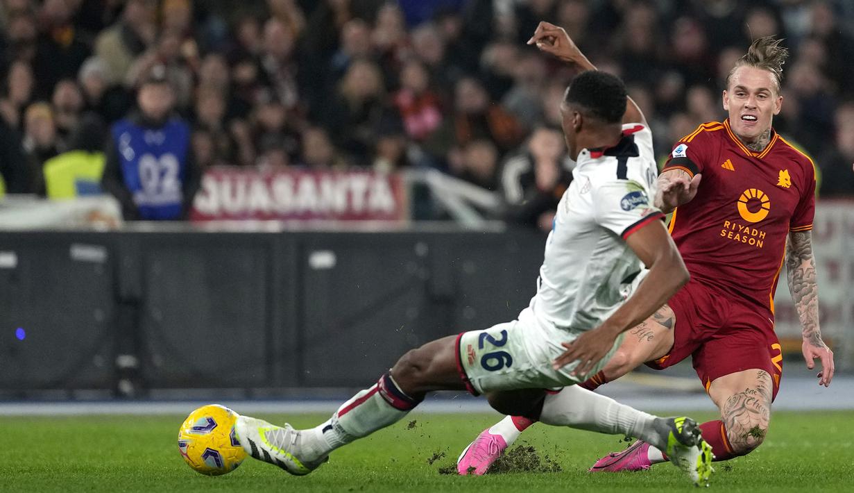 Pemain AS Roma, Rick Karsdorp (kanan) berebut bola dengan pemain Cagliari, Yerry Mina pada laga lanjutan Liga Italia 2023/2024 di Olympic Stadium, Roma, Italia, Selasa (06/02/2024) dini hari WIB. (AP Photo/Andrew Medichini)