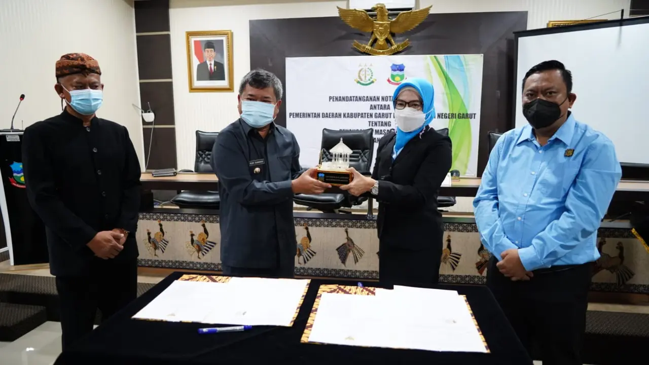 Bupati Garut Rudy Gunawan bersama Kajari Garut Neva Sari Susanti menujukan dokumen MoU pendampingan hukum kedua belah pihak di Aula Setda Garut, Jawa Barat.