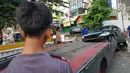 Petugas berusaha mengevakuasi mobil yang terguling di kawasan Pasar Minggu, Jakarta Selatan, Sabtu (8/6/2019) pagi. Mobil yang nyaris tercebur sungai itu dikendarai seorang pemuda yang nekat melakukan aksi kebut-kebutan saat jalanan ibu kota lengang. (Liputan6.com/Herman Zakharia)