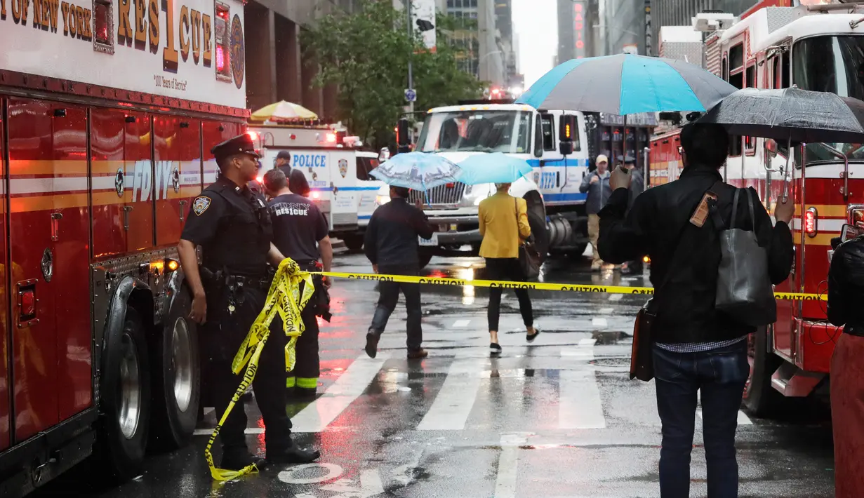 Petugas memasang garis polisi di lokasi jatuhnya helikopter di pusat Manhattan, New York, Amerika Serikat, Senin (10/6/2019). Kecelakaan terjadi saat cuaca di atas gedung AXA Equitable Centre yang memiliki ketinggian 229 meter tengah dilanda hujan. (AP Photo/Mark Lennihan)