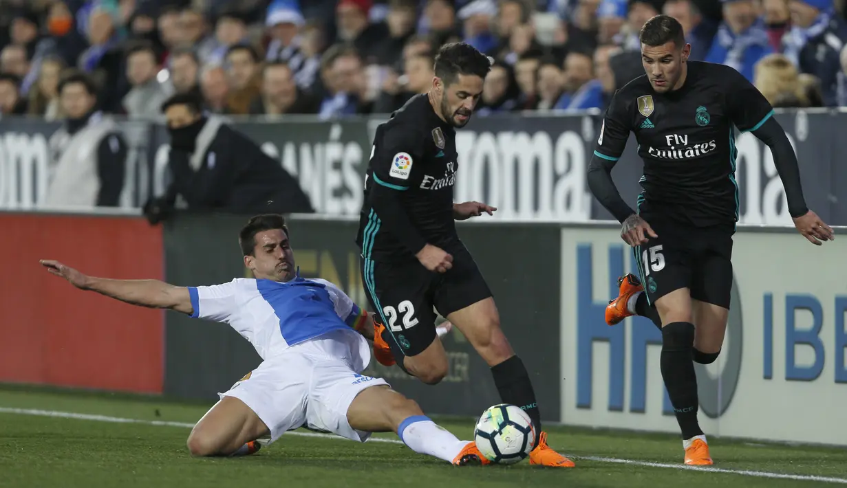 Pemain Real Madrid, Francisco Roman "Isco", (tengah) berusaha melewati adangan pemain Leganes, Gabriel Appelt (kiri) pada lanjutan La Liga Santander di Butarque stadium, Leganes, (21/2/2018). Real Madrid menang 3-1.  (AP/Francisco Seco)
