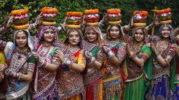 Para wanita mengenakan pakaian tradisional sebelum berlatih tarian tradisional negara bagian Gujarat, Garba, jelang Festival Navratri di Ahmadabad, India, Jumat (1/10/2021). Festival Navratri yang berlangsung sembilan malam pada musim gugur akan dimulai dari 7 Oktober. (AP Photo/Ajit Solanki)