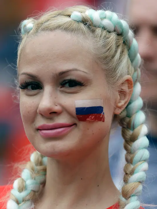 Suporter wanita tersenyum sebelum pertandingan grup A Piala Dunia 2018 antara Rusia dan Arab Saudi di stadion Luzhniki di Moskow, (14/6). Dalam pertandingan ini, Rusia menang 5-0 atas Arab Saudi. (AP Photo/ Matthias Schrader)