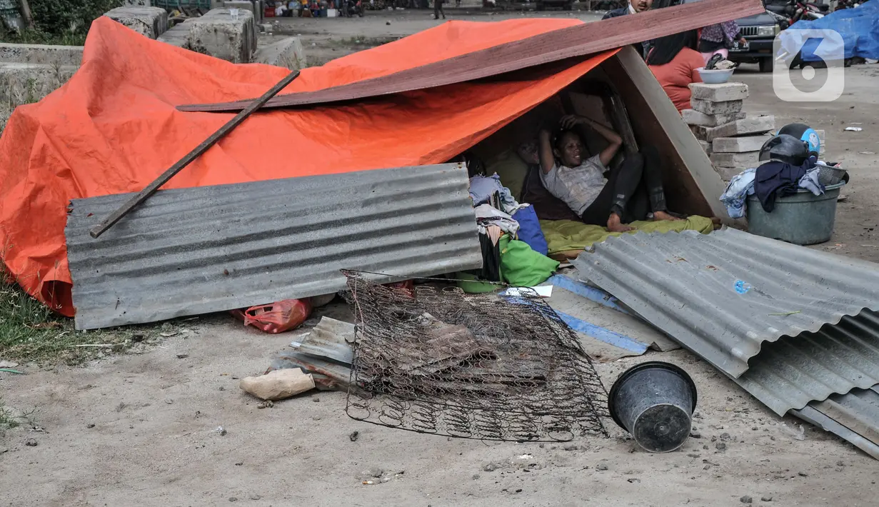 Warga membangun tempat tinggal sementara pascapenggusuran ratusan bangunan semipermanen di Kampung Bambu, Tanjung Priok, Jakarta Utara, Selasa (11/10/2022). PT KAI membongkar sekitar 254 bangunan semipermanen yang berada di bantaran rel atau dekat Jakarta International Stadium (JIS) guna sterilisasi jalur kereta api dan pembangunan stasiun baru di kawasan tersebut. (merdeka.com/Iqbal S. Nugroho)