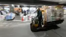 Pekerja mengoperasikan truk turret di antara toko-toko pada hari pertama pembukaan pasar ikan Toyosu yang baru,  di Tokyo, Kamis (11/9). Pasar ikan Toyosu menggantikan pasar ikan legendaris yang sudah mendunia, Pasar Tsukiji. (Toshifumi KITAMURA/AFP)