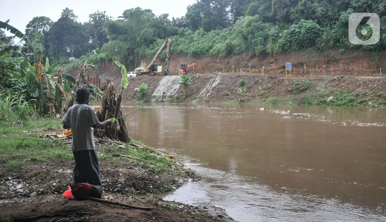 Warga memancing di dekat proyek pembangunan saringan sampah Kali Ciliwung segmen Jalan TB Simatupang, Jakarta, Minggu (12/2/2023).  Kepala Dinas Lingkungan Hidup DKI Jakarta Asep Kuswanto mengatakan pengerjaan proyek saringan sampah di Jalan TB Simatupang molor dari target. (merdeka.com/Iqbal S Nugroho)