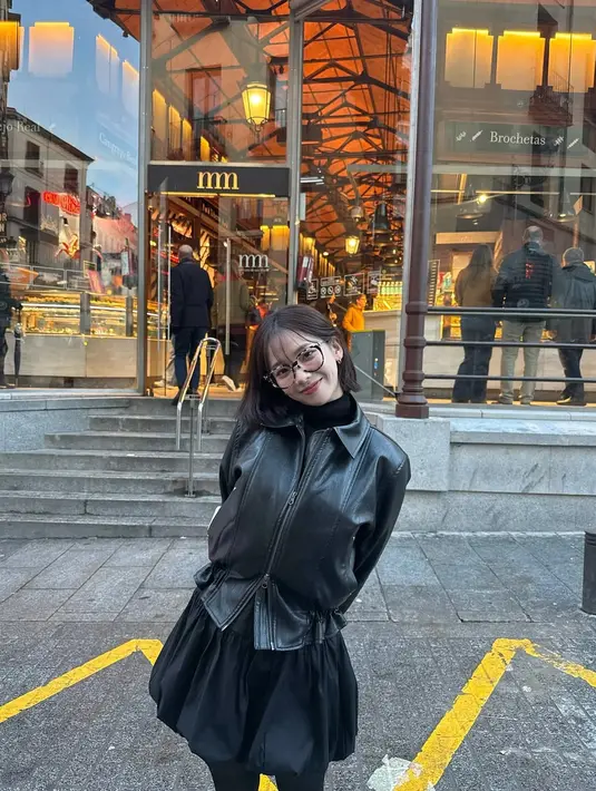 Kenakan outfit satu warna, Karina aespa kembali terapkan teknik layering. Ia padukan turtleneck berlapis jaket kulit dengan rok mini balon dan stocking hitam [@katarinabluu]