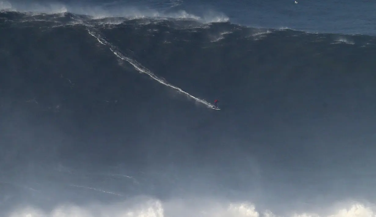 Peselancar asal Brasil Marcelo Luna beraksi saat menaklukan ombak selama sesi surfing ombak besar di Praia do Norte di Nazare, Portugal tengah (13/1). (AP Photo / Armando Franca)